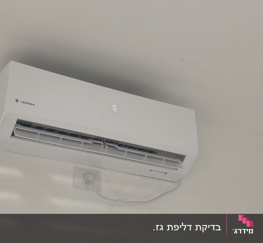 מזגן קיר לבן עם תצוגת טמפרטורה